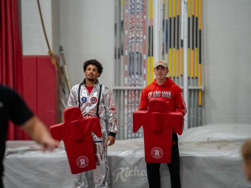 two men wearing suits and standing next to each other
