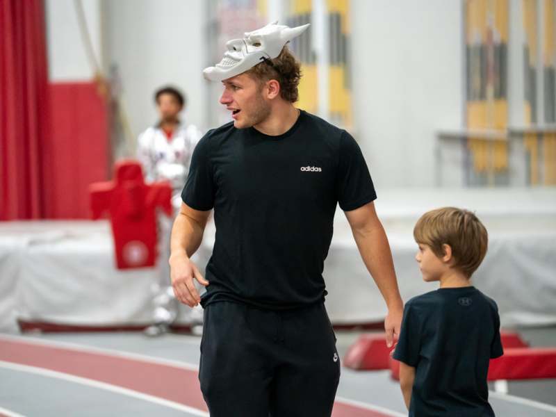 a man wearing a mask and walking with a boy