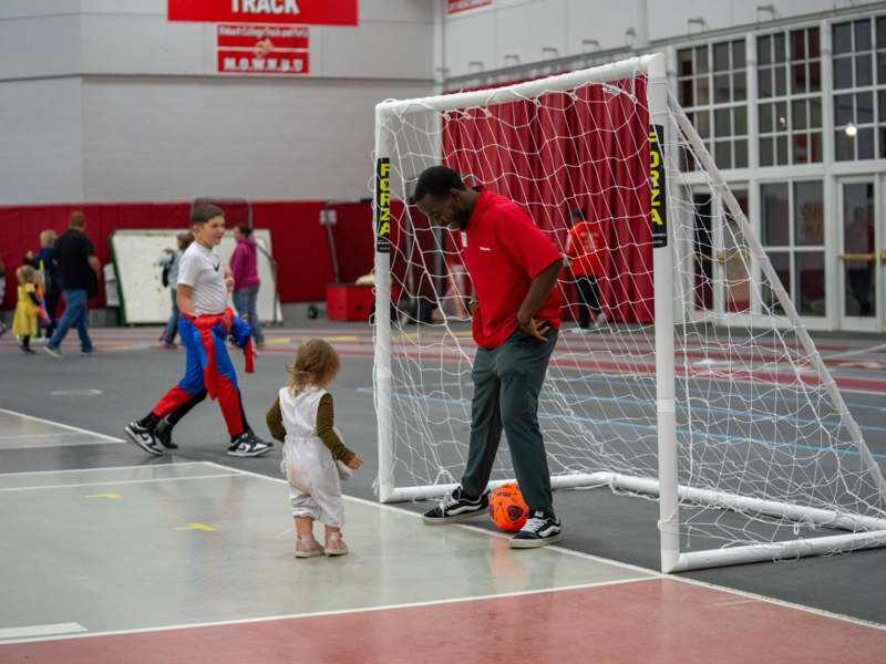 a man standing next to a child in a football goal