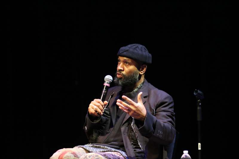 a man sitting in a chair holding a microphone