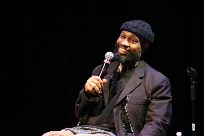 a man sitting on a chair holding a microphone