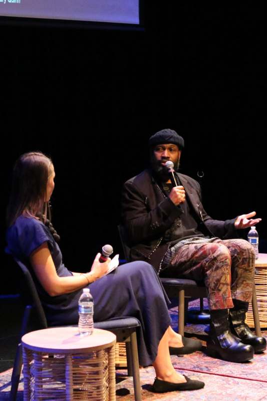 a man sitting in chairs with a microphone in front of a woman