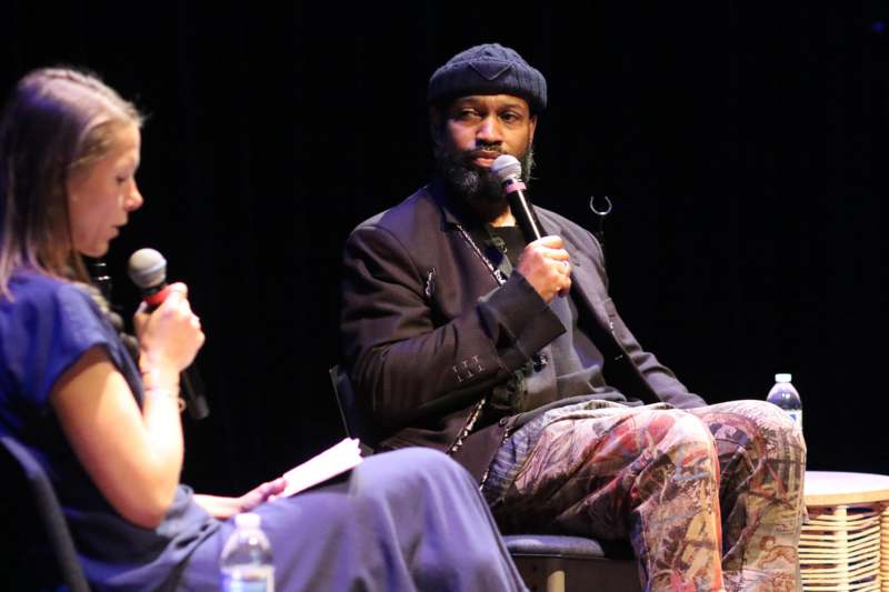 a man sitting in a chair holding a microphone