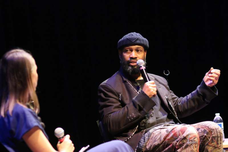 a man holding a microphone and sitting in front of a woman