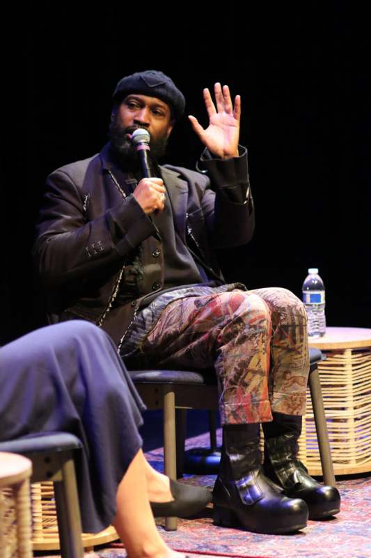 a man sitting in a chair holding a microphone