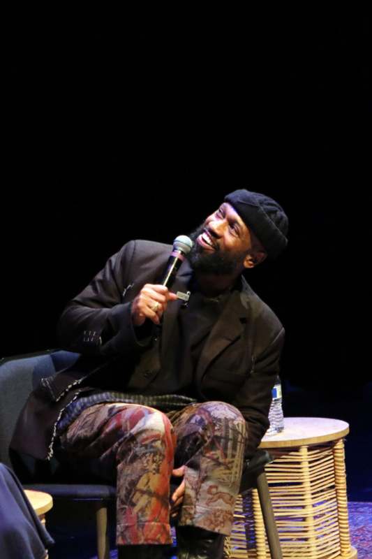 a man sitting on a chair holding a microphone