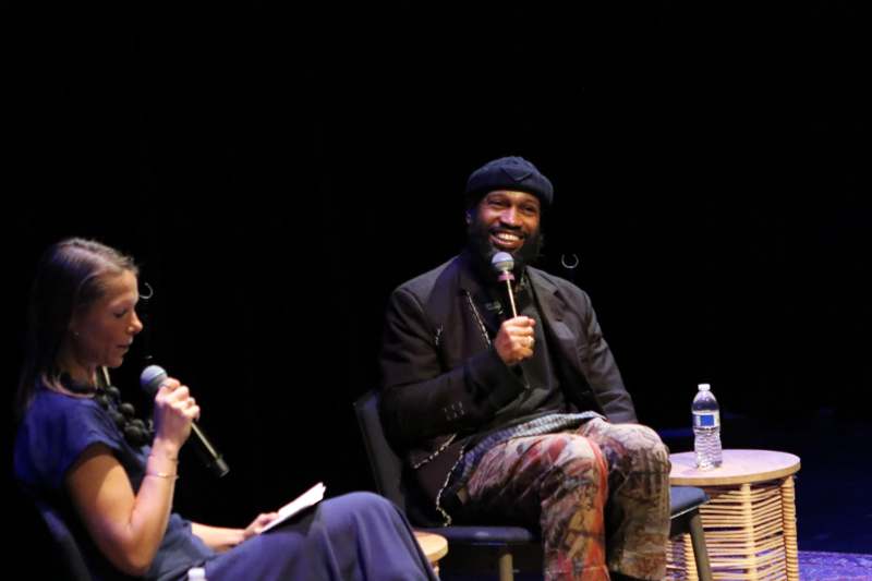 a man sitting in a chair with a microphone in front of a woman