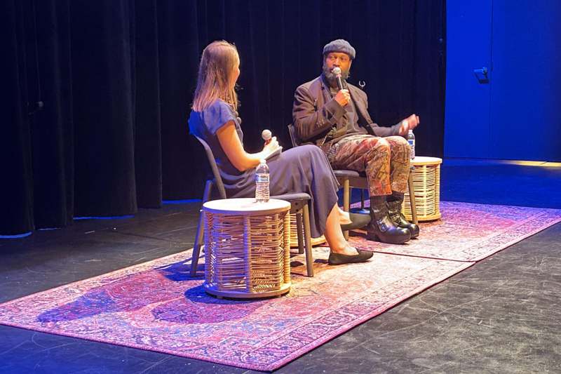 a man and woman sitting on a stage