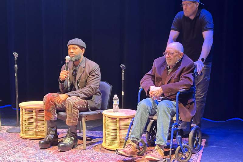 a group of men sitting on a stage