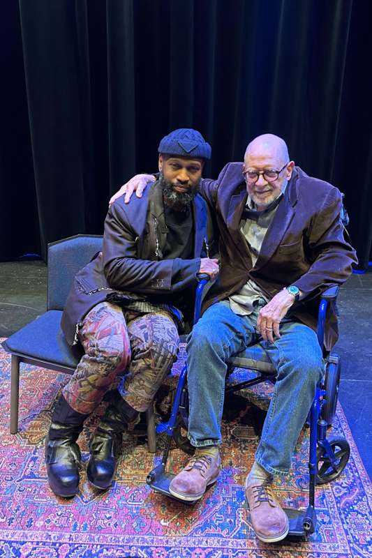 two men sitting on a chair