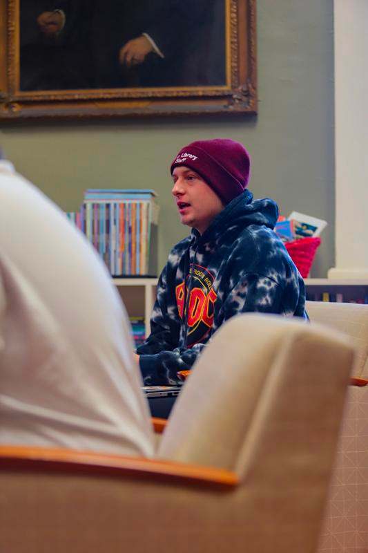 a man in a beanie sitting in a chair