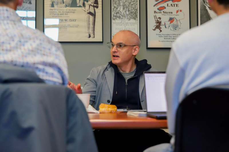 a man sitting at a table with a group of people
