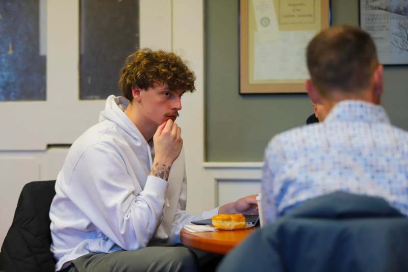 a man sitting at a table with a donut and a donut