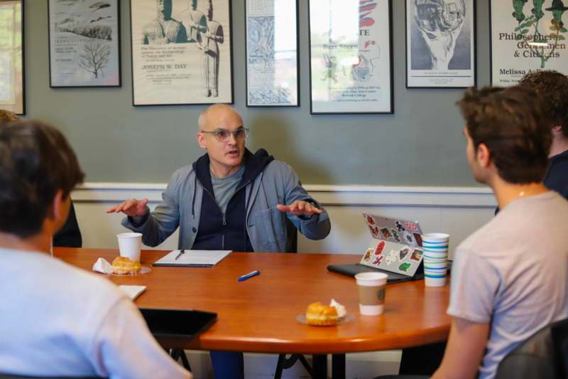 a man talking to a group of people at a table