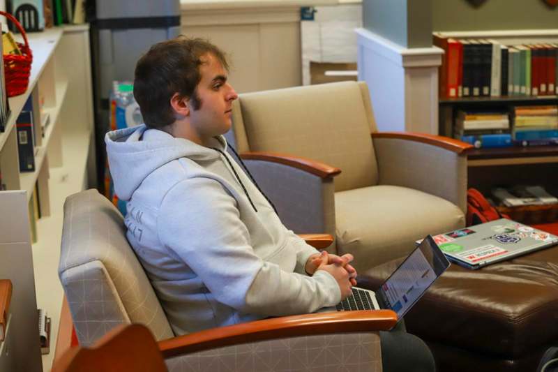 a man sitting in a chair with a laptop