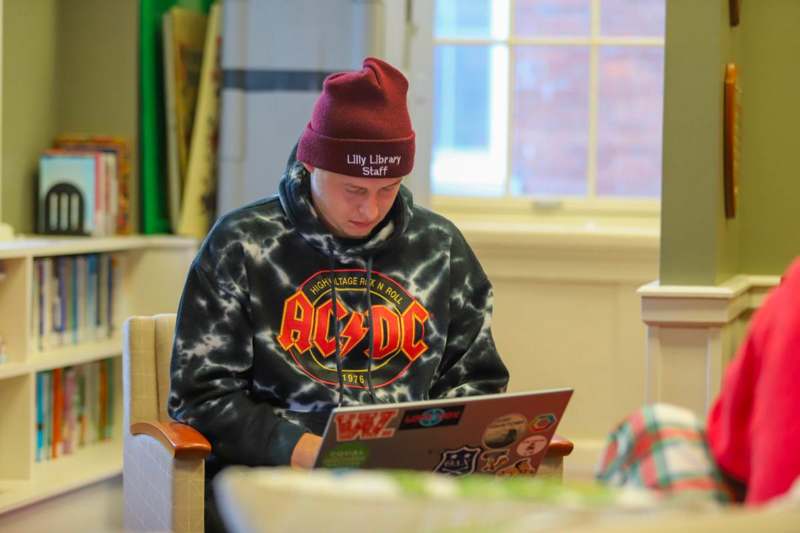 a man sitting in a chair using a laptop