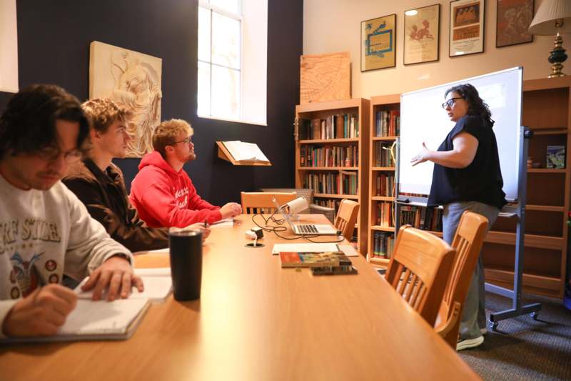 a woman standing in front of a whiteboard