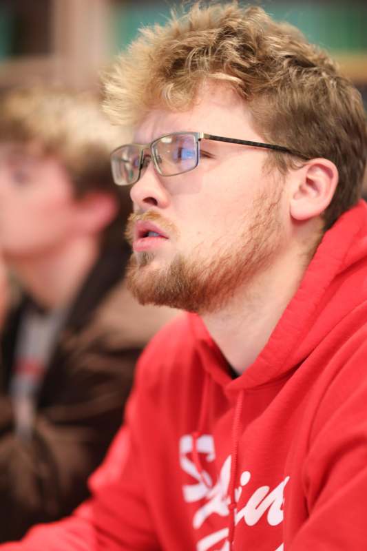 a man wearing glasses and a red sweatshirt