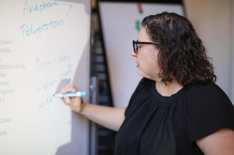 a woman writing on a whiteboard