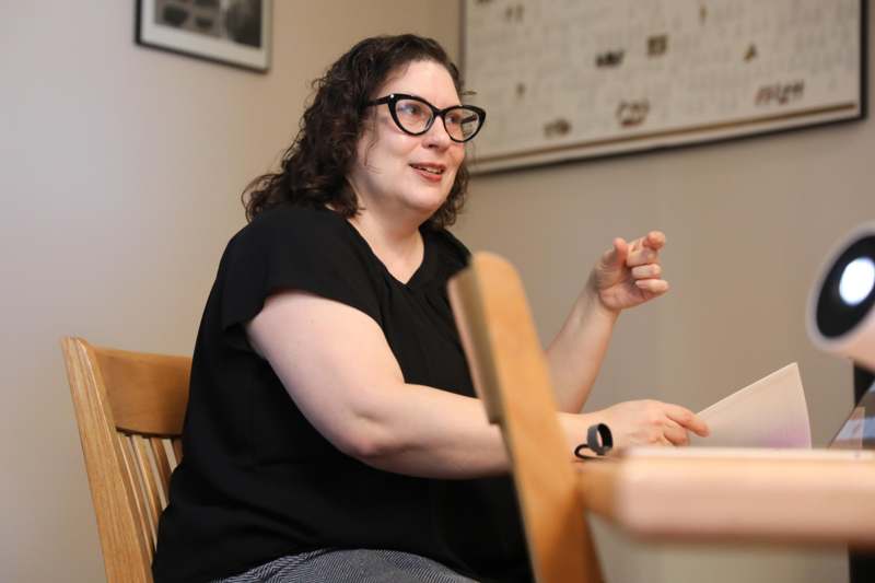 a woman sitting in a chair pointing at something
