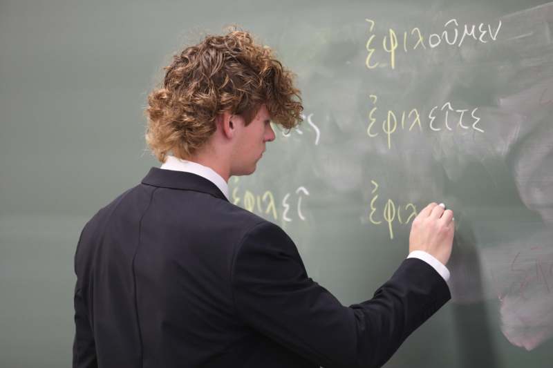 a man writing on a chalkboard