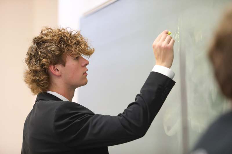a man writing on a blackboard