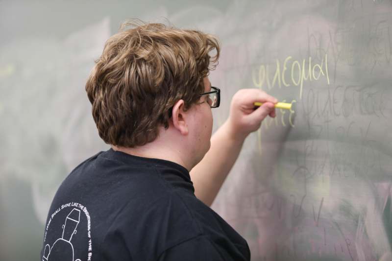 a man writing on a chalkboard