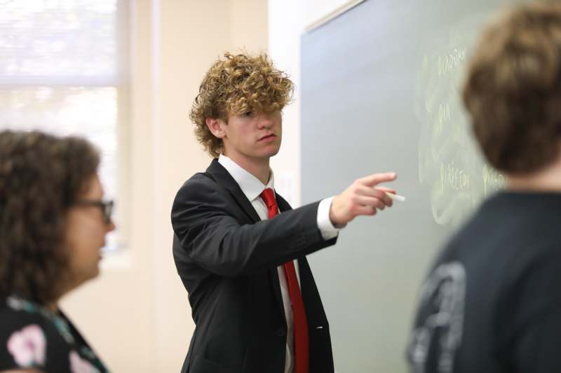 a man pointing at a chalk board