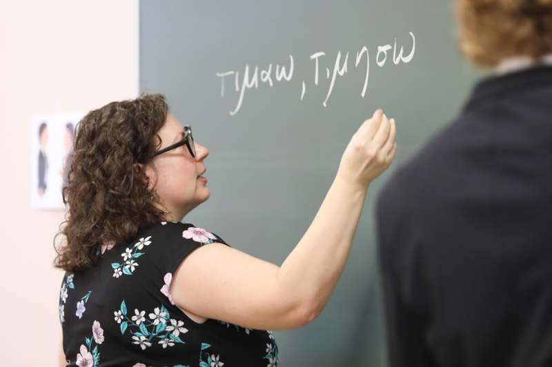 a woman writing on a chalkboard