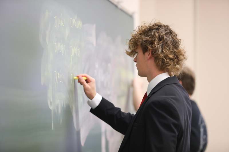 a man writing on a chalkboard