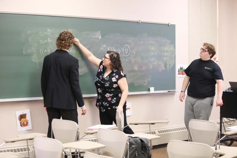 a woman writing on a chalkboard
