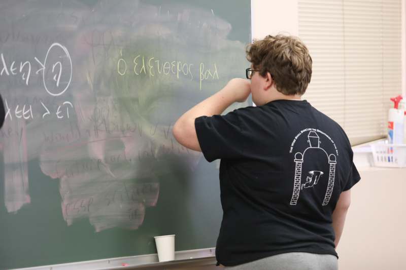 a boy writing on a chalkboard