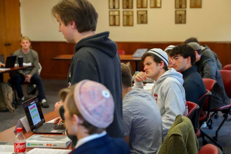 a group of people sitting in a room with a laptop