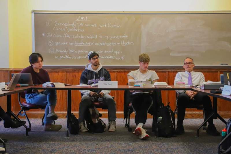 a group of people sitting at a long table