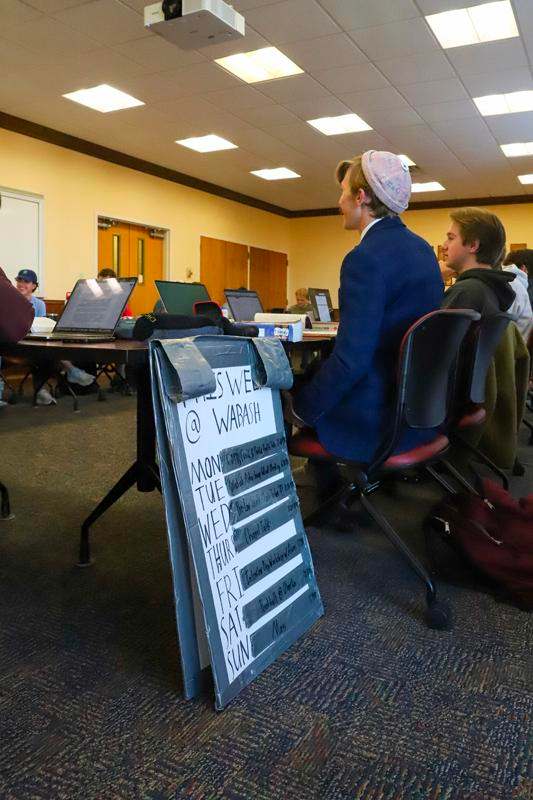 a man sitting in a room with a sign