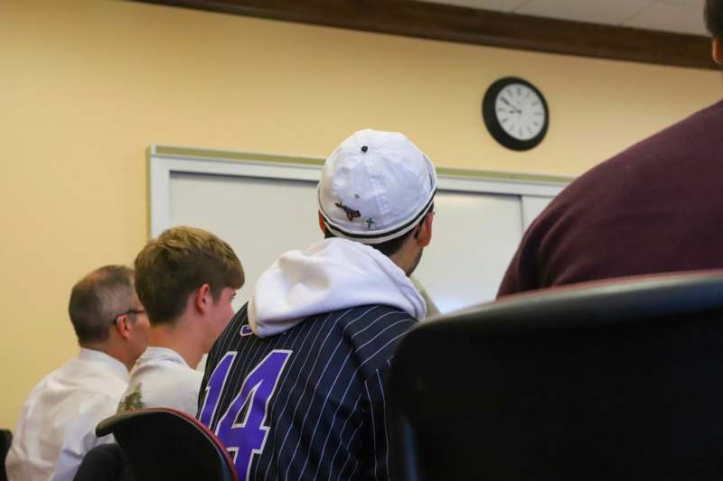 a man wearing a baseball cap in a classroom