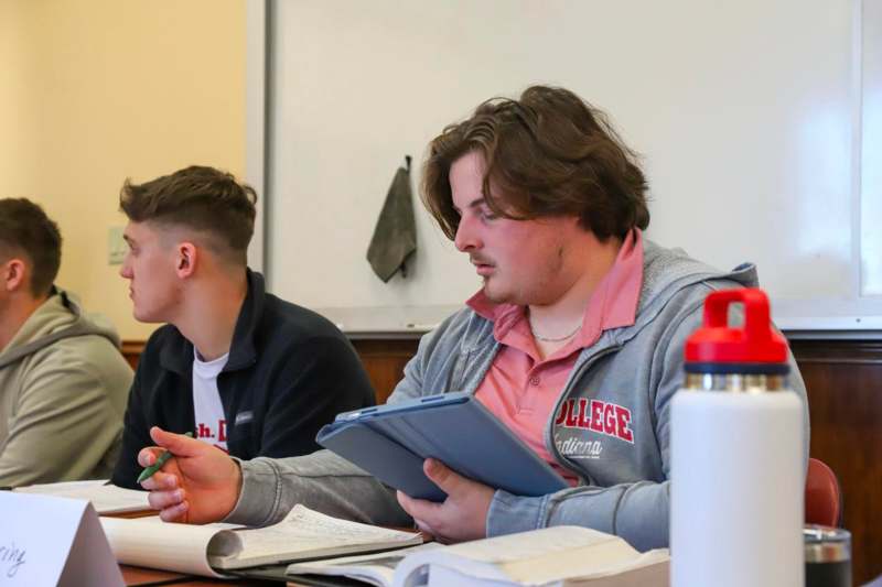 a man holding a tablet and a pen