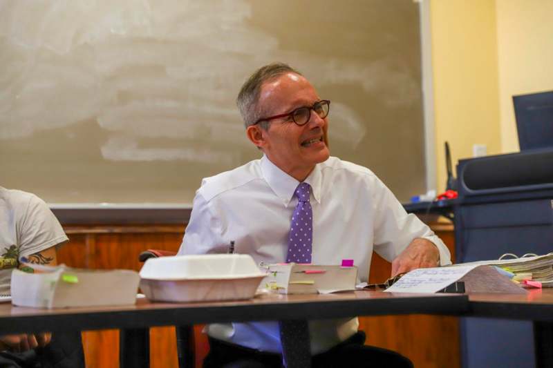 a man in a tie sitting at a desk