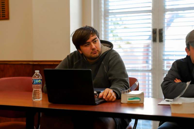 a man sitting at a desk with a laptop
