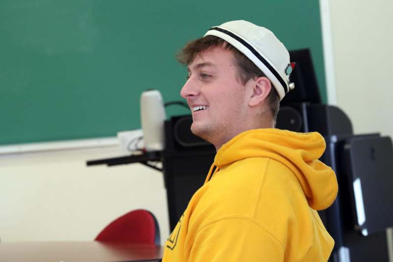 a man in a yellow hoodie and hat