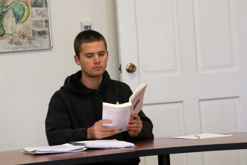 a man sitting at a table reading a book