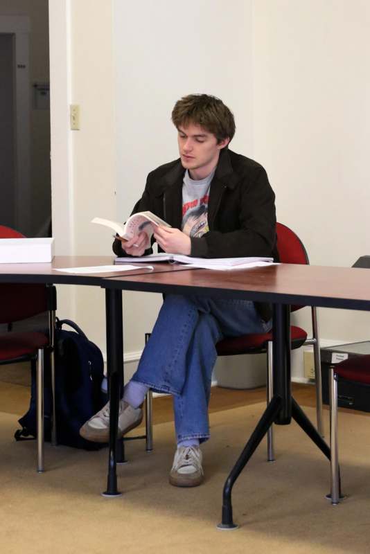 a man sitting at a table reading a book