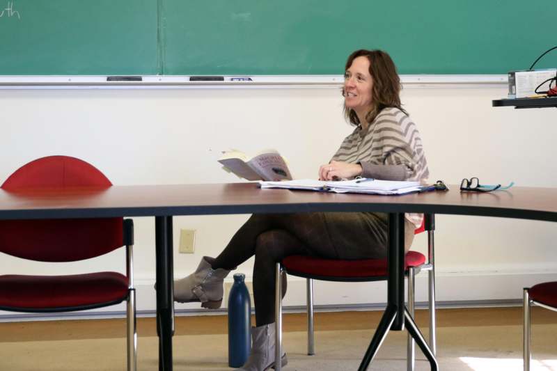 a woman sitting at a table with a book