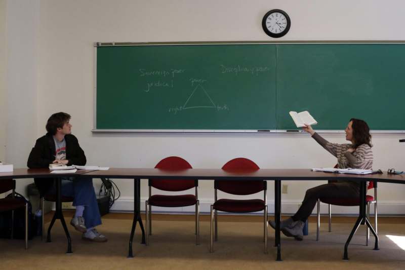 a woman holding a book to another woman