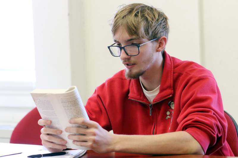 a man in a red jacket reading a book