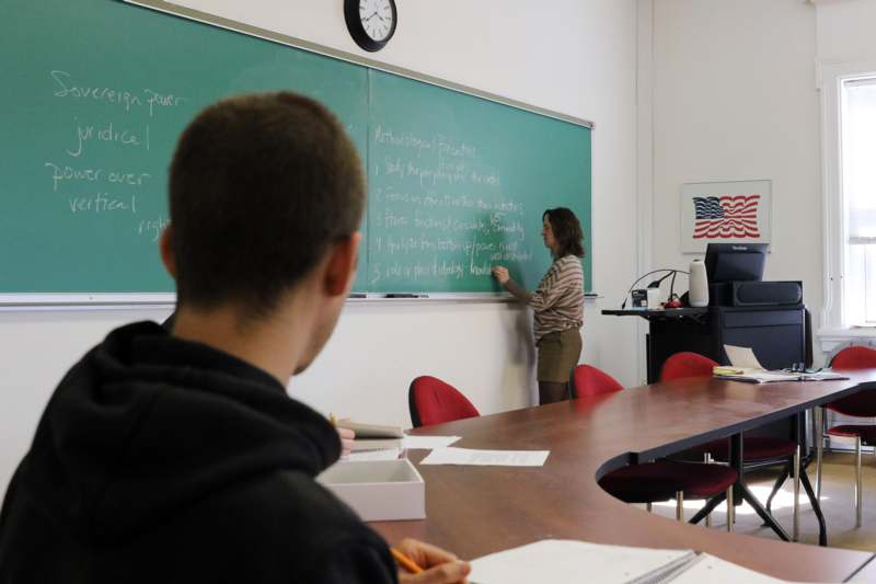 a woman writing on a chalkboard