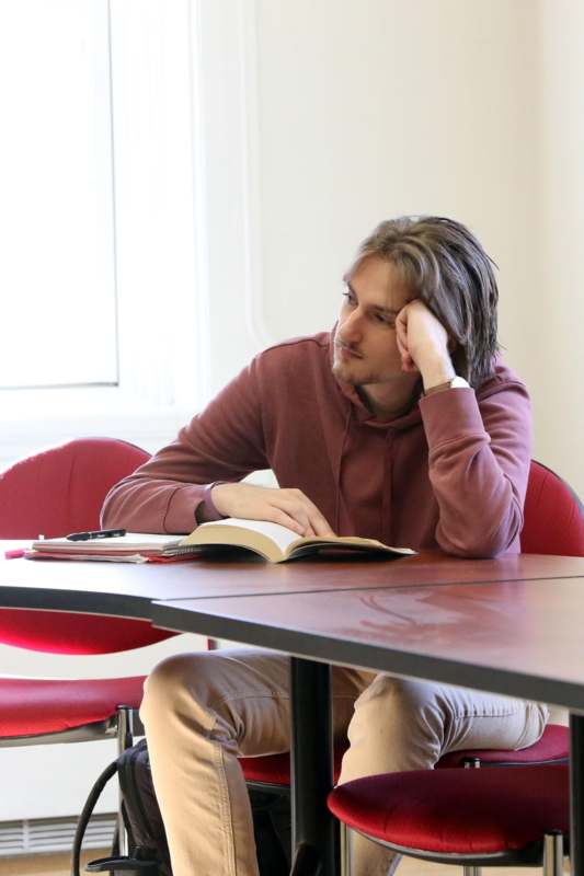 a man sitting at a table with a book