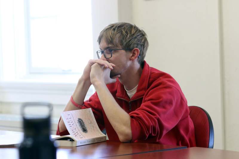 a man sitting at a table with his hands on his face