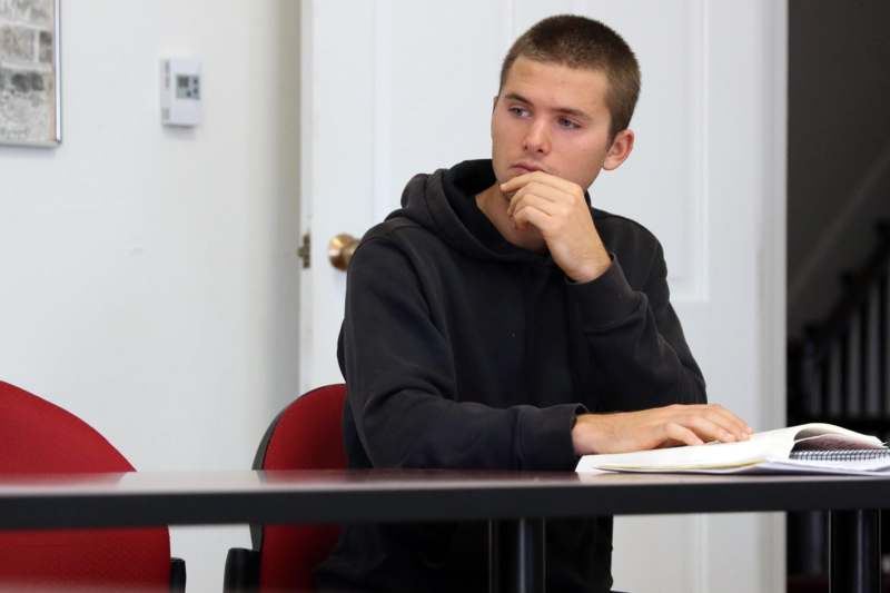 a man sitting at a table with his hand on his chin