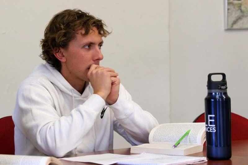 a man sitting at a desk with his hands clasped together